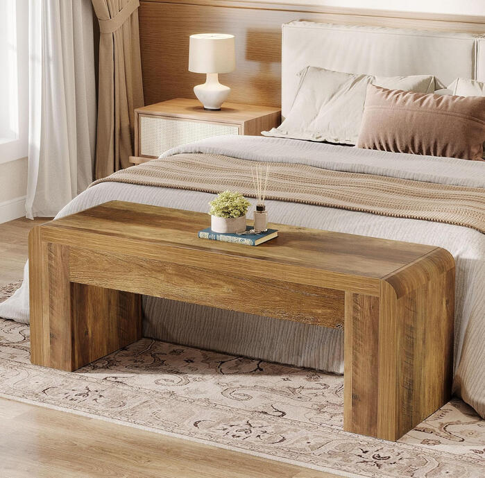 Natural oak waterfall-edge bench at the foot of a bed, with rounded corners and minimalist farmhouse style.