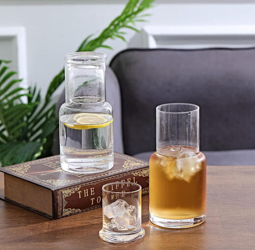 Minimalist glass bedside carafe with tumbler, mid-century inspired design for water or nightstand use.