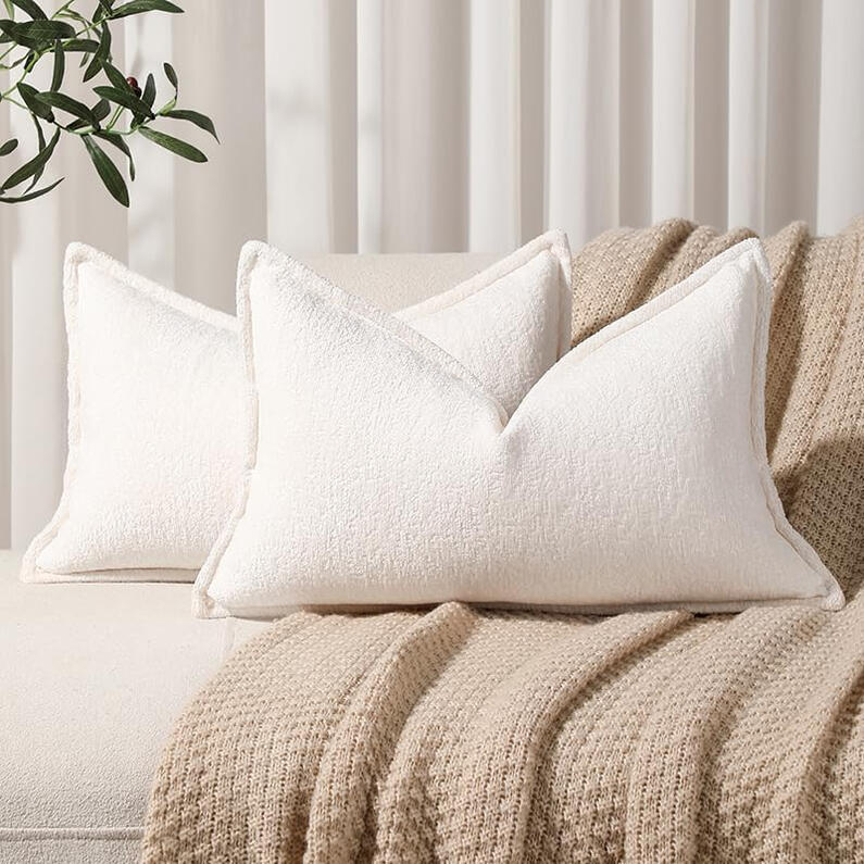 Set of two soft chenille pillow covers in neutral beige tones with flange edging, styled on a linen bedspread.
